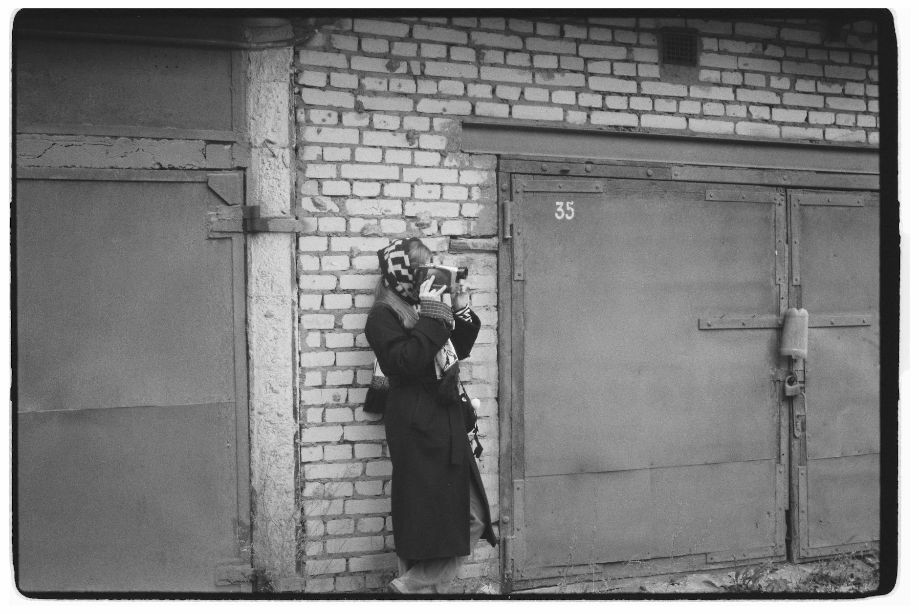 Czarno-białe zdjęcie fotografa z aparatem w miejskim otoczeniu