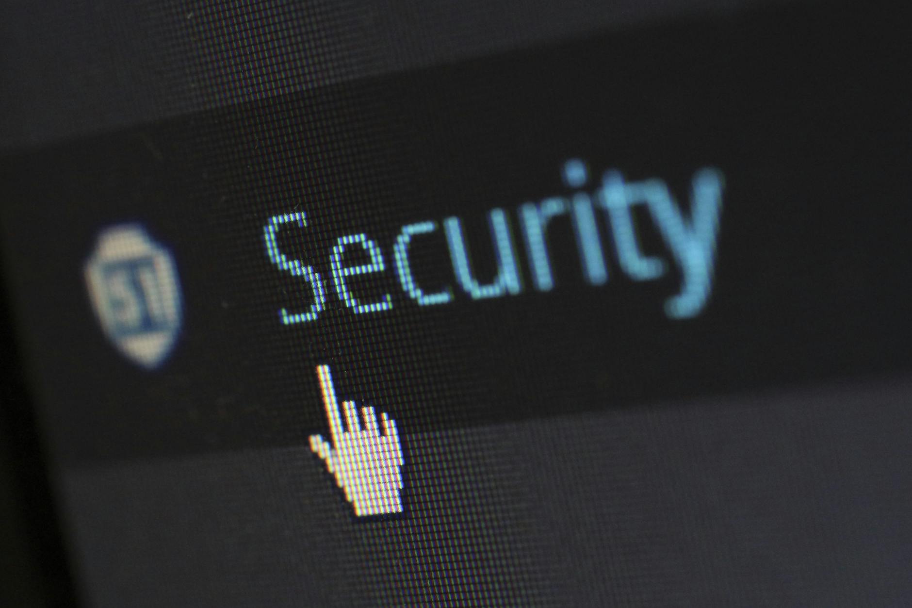 Kursor myszy na tekście o cyberbezpieczeństwie na ekranie monitora