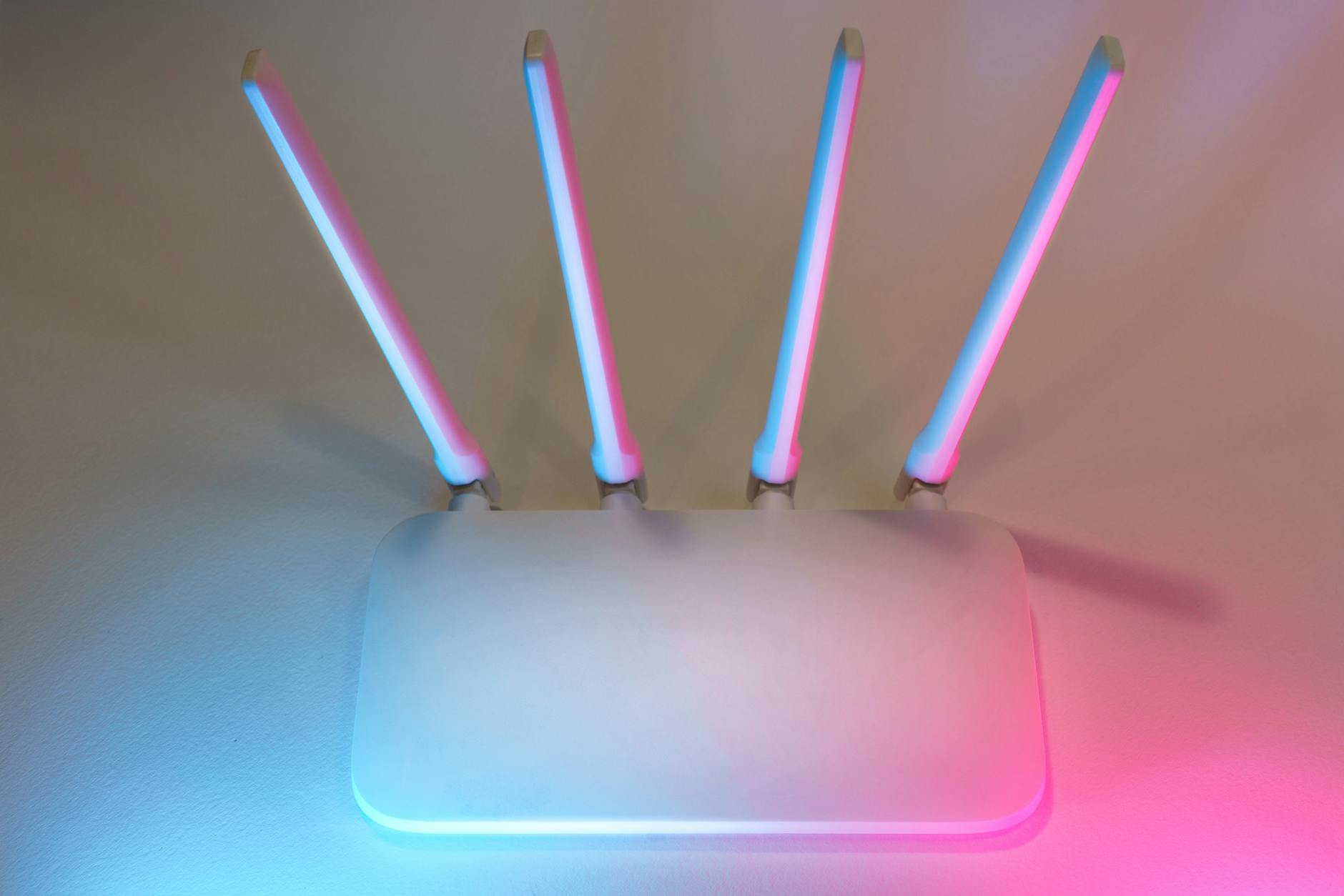 Nowoczesny biały router WiFi z czterema antenami w niebiesko-różowym świetle