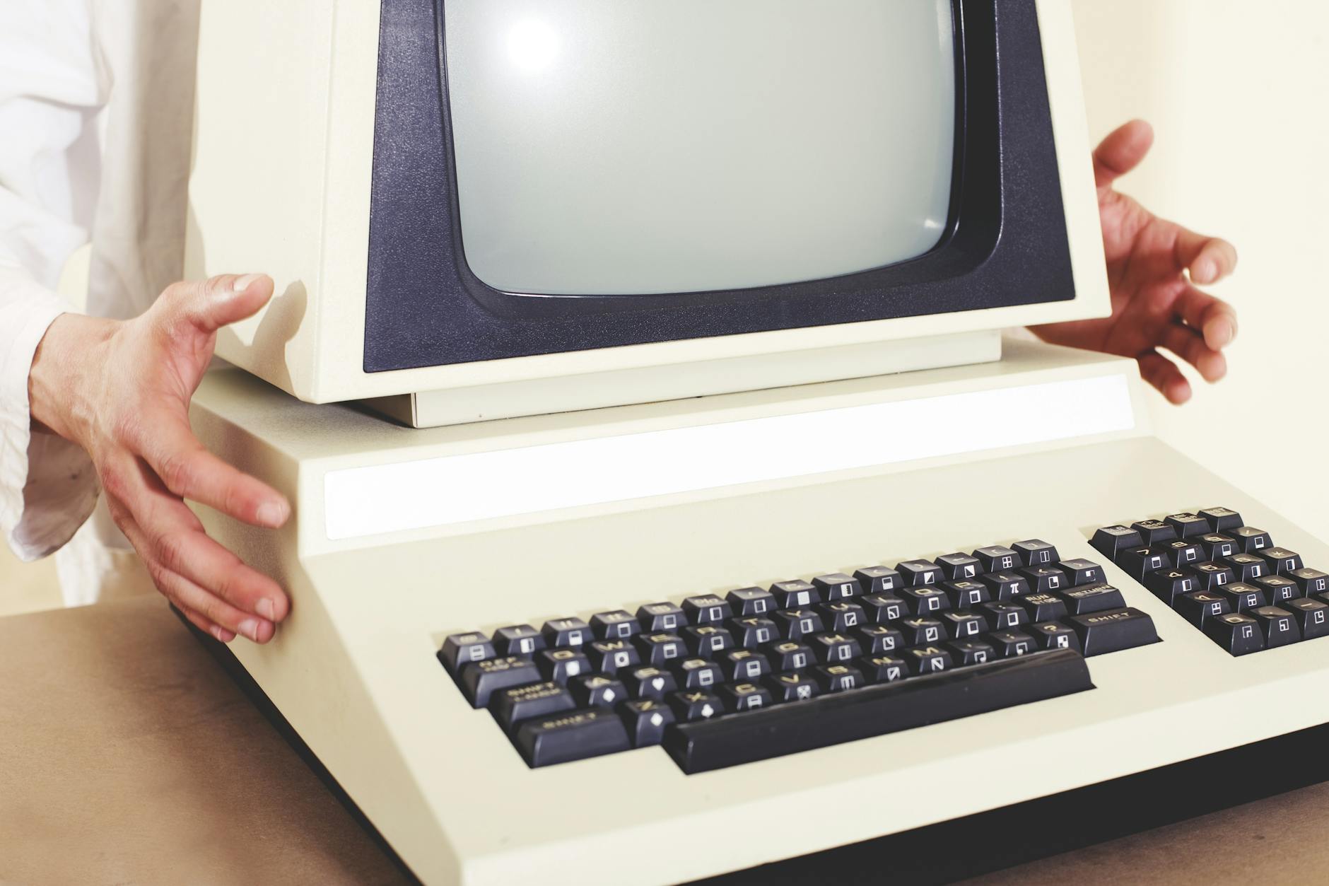 Stary komputer z monitorem CRT trzymany w obu rękach